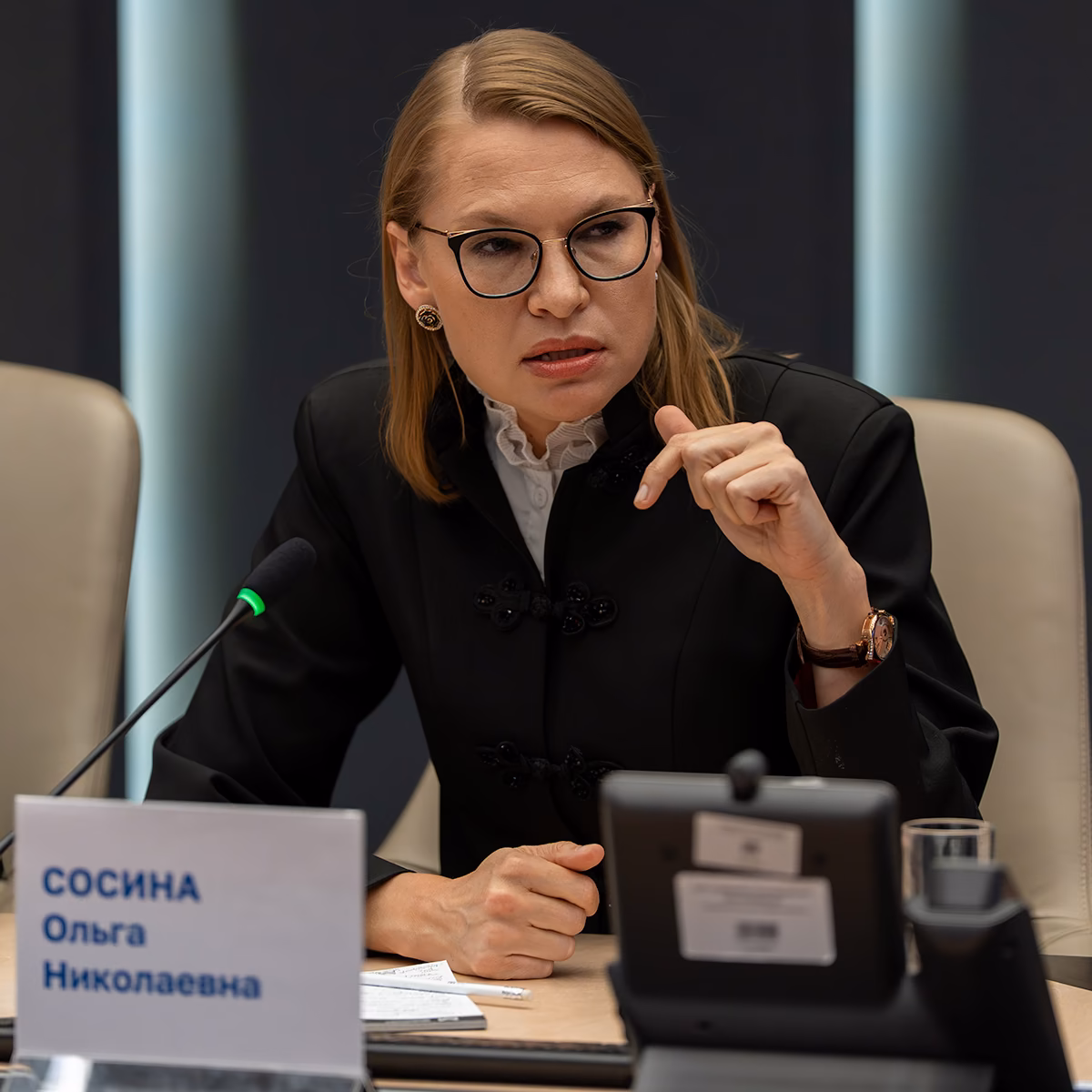 Ольга Сосина выступает с микрофоном за столом