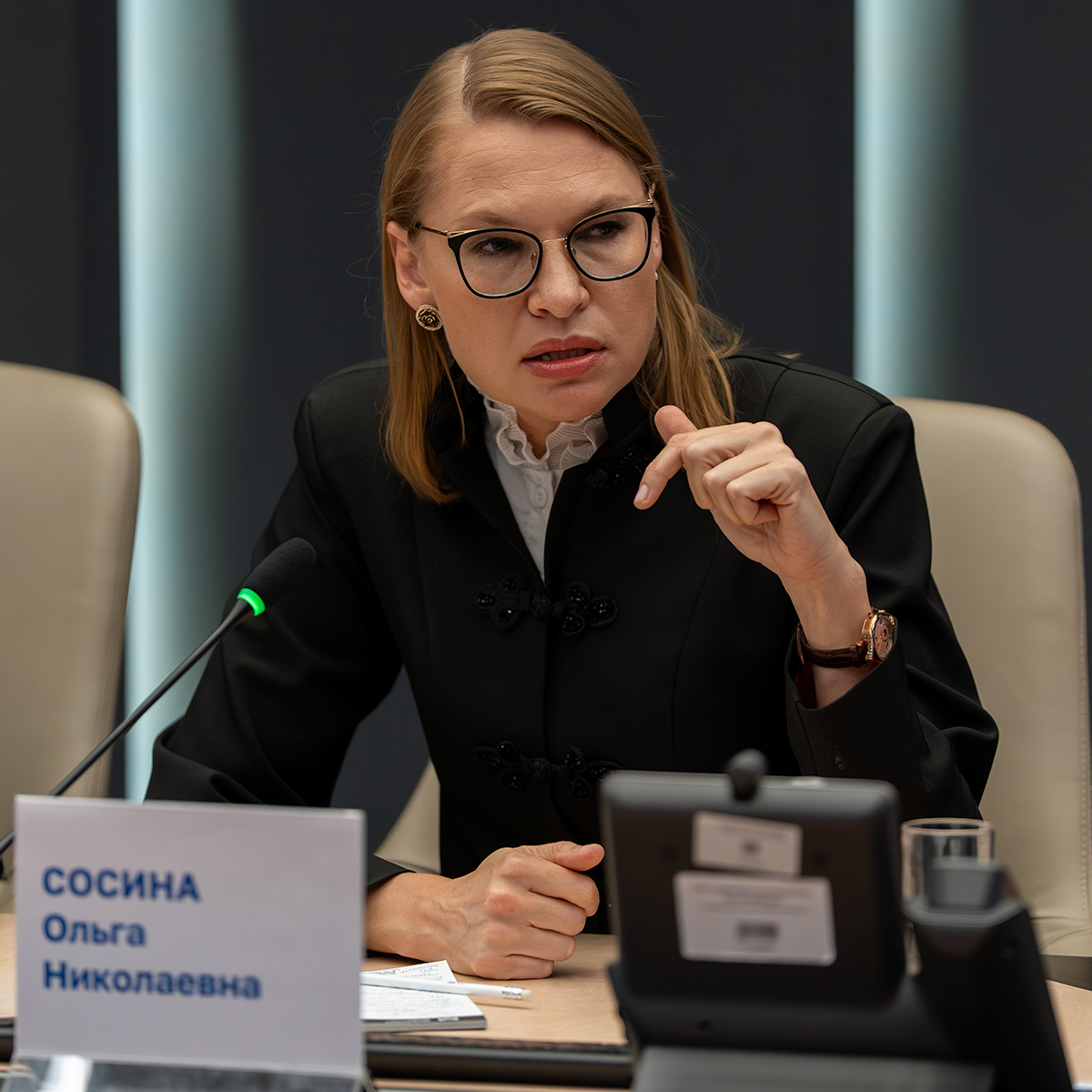 Ольга Сосина выступает с микрофоном за столом